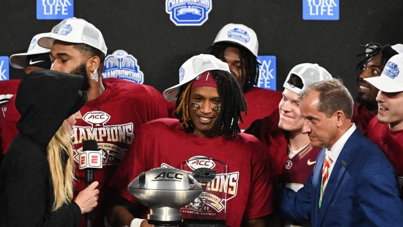 Dec 2, 2023; Charlotte, NC, USA; Florida State Seminoles running back Lawrance Toafili (9) is awarded the ACC Championship MVP trophy after the game against the Louisville Cardinals at Bank of America Stadium. Mandatory Credit: Bob Donnan-USA TODAY Sports