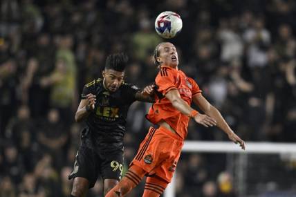 Dec 2, 2023; Los Angeles, California, USA; Houston Dynamo midfielder Griffin Dorsey (25) heads the ball past Los Angeles FC forward Denis Bouanga (99) for the MLS Cup Western Conference Final at BMO Stadium. Mandatory Credit: Kelvin Kuo-USA TODAY Sports