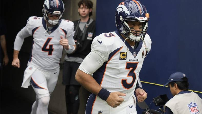 Dec 3, 2023; Houston, Texas, USA; Denver Broncos quarterback Russell Wilson (3) and quarterback Jarrett Stidham (4) run out on the field before playing against the Houston Texans at NRG Stadium. Mandatory Credit: Thomas Shea-USA TODAY Sports