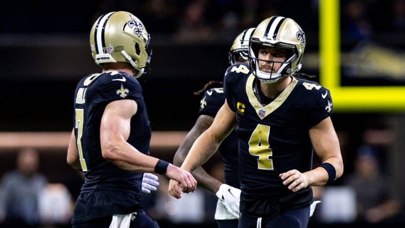 Dec 3, 2023; New Orleans, Louisiana, USA; New Orleans Saints quarterback Derek Carr (4) talks to quarterback Taysom Hill (7) against the Detroit Lions during the first half at the Caesars Superdome. Mandatory Credit: Stephen Lew-USA TODAY Sports