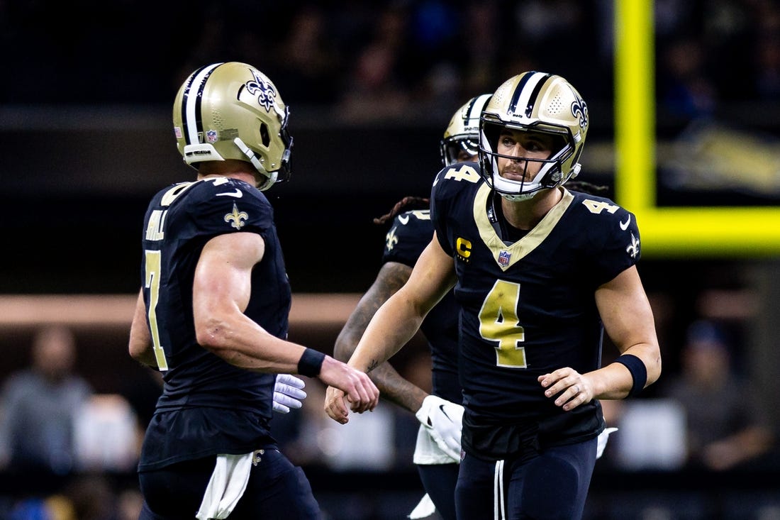 Dec 3, 2023; New Orleans, Louisiana, USA; New Orleans Saints quarterback Derek Carr (4) talks to quarterback Taysom Hill (7) against the Detroit Lions during the first half at the Caesars Superdome. Mandatory Credit: Stephen Lew-USA TODAY Sports