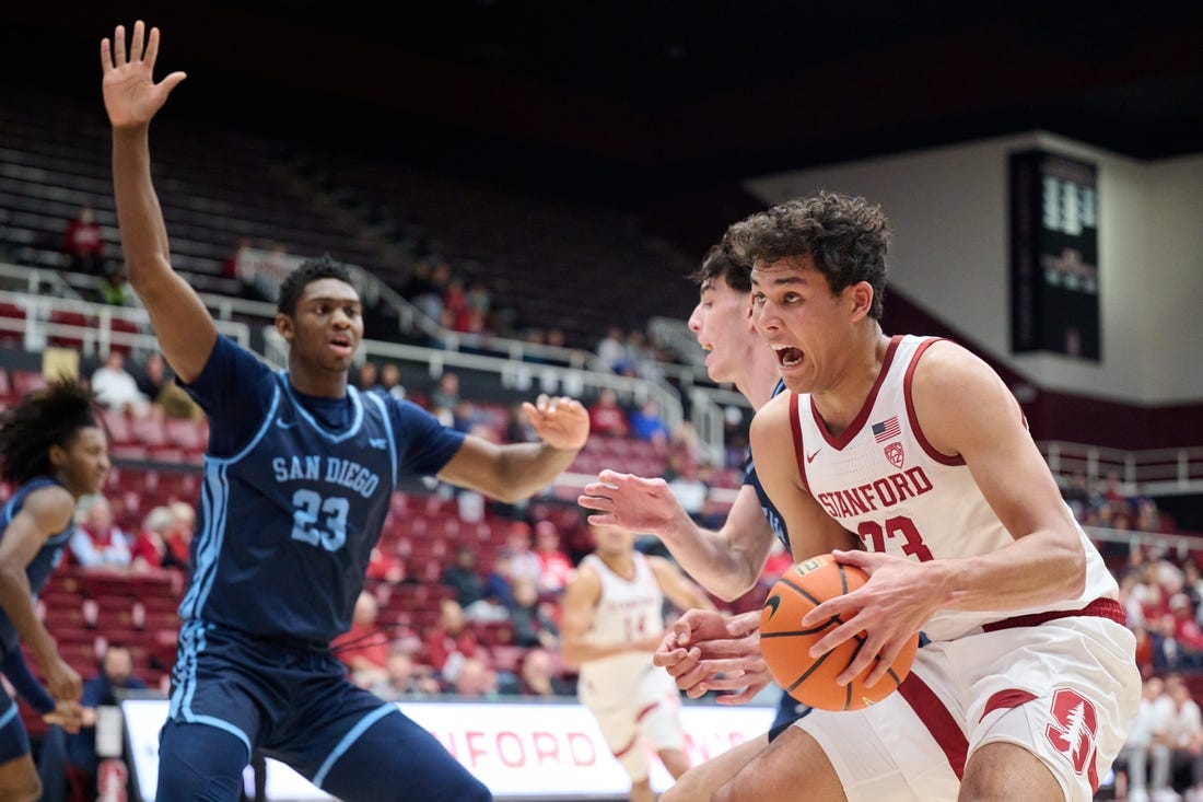 Dec 3, 2023; Stanford, California, USA; Stanford Cardinal forward Brandon Angel (23) controls the ball against San Diego Toreros forward Jimmy Oladokun Jr. (23) during the first half at Maples Pavilion. Mandatory Credit: Robert Edwards-USA TODAY Sports