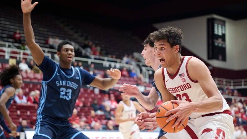 Dec 3, 2023; Stanford, California, USA; Stanford Cardinal forward Brandon Angel (23) controls the ball against San Diego Toreros forward Jimmy Oladokun Jr. (23) during the first half at Maples Pavilion. Mandatory Credit: Robert Edwards-USA TODAY Sports