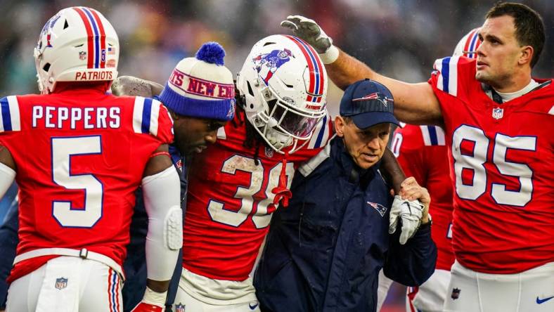 Dec 3, 2023; Foxborough, Massachusetts, USA; New England Patriots running back Rhamondre Stevenson (38) is helped off the field as they take on the Los Angeles Chargers in the second quarter at Gillette Stadium. Mandatory Credit: David Butler II-USA TODAY Sports