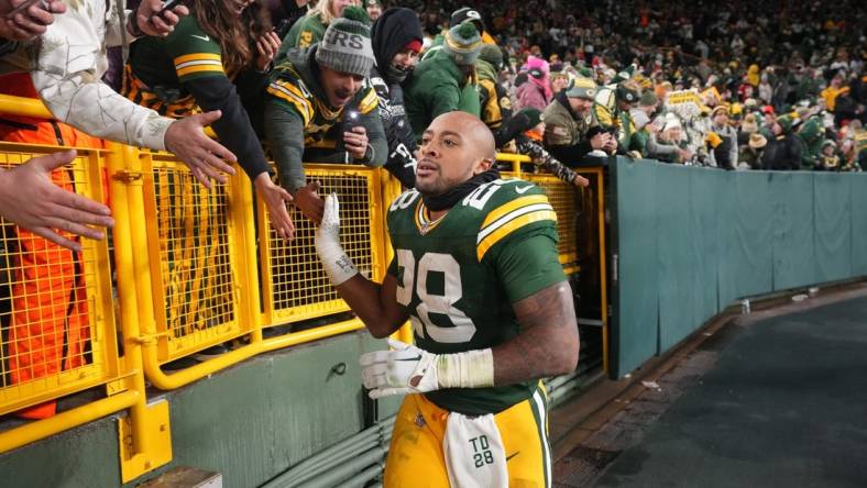 Dec 3, 2023; Green Bay, Wisconsin, USA; Green Bay Packers running back AJ Dillon (28) makes a victory lap after their game against the Kansas City Chiefs at Lambeau Field. Mandatory Credit: Mark Hoffman-USA TODAY Sports