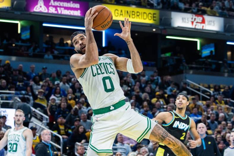 Dec 4, 2023; Indianapolis, Indiana, USA; Boston Celtics forward Jayson Tatum (0) rebounds the ball in the first half against the Indiana Pacers at Gainbridge Fieldhouse. Mandatory Credit: Trevor Ruszkowski-USA TODAY Sports