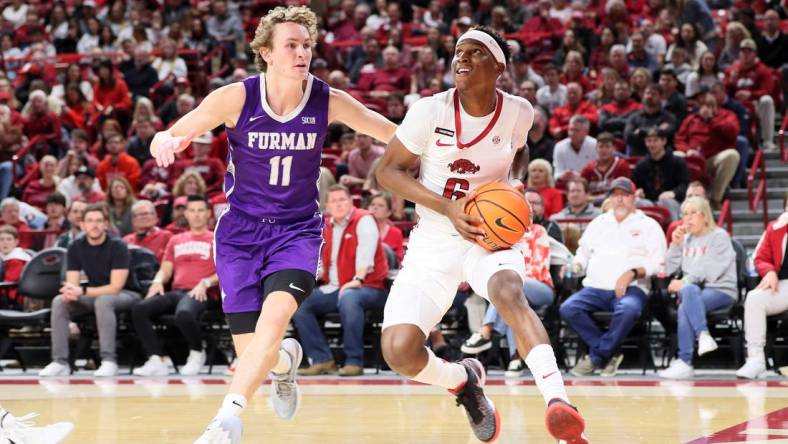 Dec 4, 2023; Fayetteville, Arkansas, USA; Arkansas Razorbacks guard Layden Blocker (6) drives against Furman Paladins guard Carter Whitt (11) during the first half at Bud Walton Arena. Mandatory Credit: Nelson Chenault-USA TODAY Sports