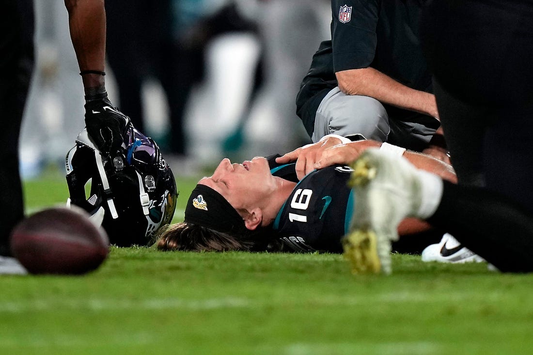 Jacksonville Jaguars quarterback Trevor Lawrence (16) is examined on the field after suffering a leg injury in the fourth quarter of a Week 13 NFL football game against the Cincinnati Bengals, Monday, Dec. 4, 2023, at EverBank Stadium in Jacksonsville, Fla.