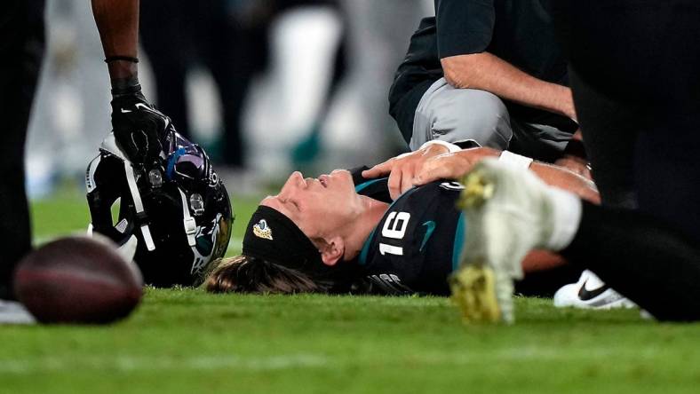 Jacksonville Jaguars quarterback Trevor Lawrence (16) is examined on the field after suffering a leg injury in the fourth quarter of a Week 13 NFL football game against the Cincinnati Bengals, Monday, Dec. 4, 2023, at EverBank Stadium in Jacksonsville, Fla.