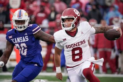 Oct 28, 2023; Lawrence, Kansas, USA; Oklahoma Sooners quarterback Dillon Gabriel (8) runs the ball as Kansas Jayhawks linebacker Rich Miller (30) defends during the game at David Booth Kansas Memorial Stadium. Mandatory Credit: Denny Medley-USA TODAY Sports