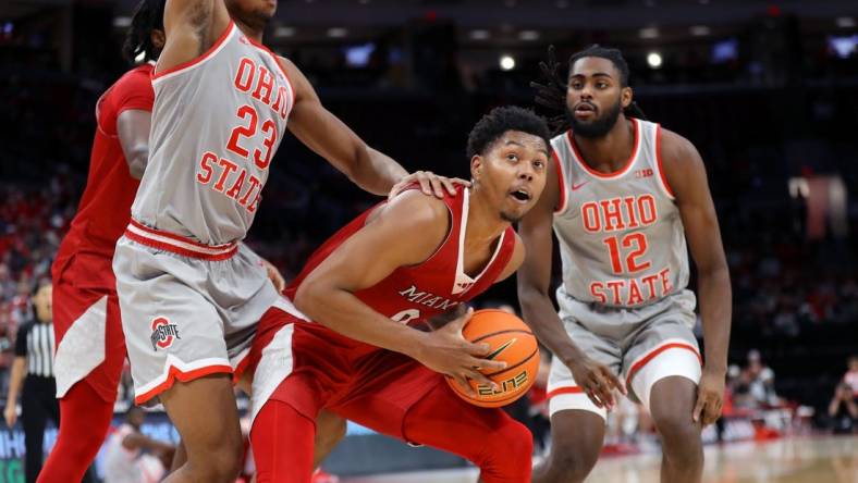 Dec 6, 2023; Columbus, Ohio, USA; Miami (Oh) Redhawks guard Eian Elmer (0) looks to score as Ohio State Buckeyes forward Zed Key (23) and guard Evan Mahaffey (12) defend during the first half at Value City Arena. Mandatory Credit: Joseph Maiorana-USA TODAY Sports