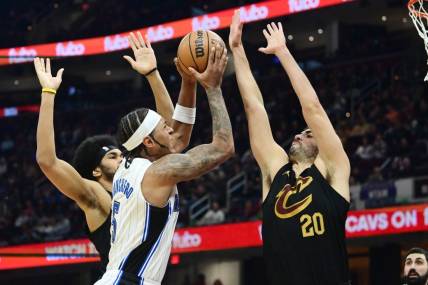 Dec 6, 2023; Cleveland, Ohio, USA; Orlando Magic forward Paolo Banchero (5) drives to the basket between Cleveland Cavaliers center Jarrett Allen (31) and forward Georges Niang (20) during the first half at Rocket Mortgage FieldHouse. Mandatory Credit: Ken Blaze-USA TODAY Sports