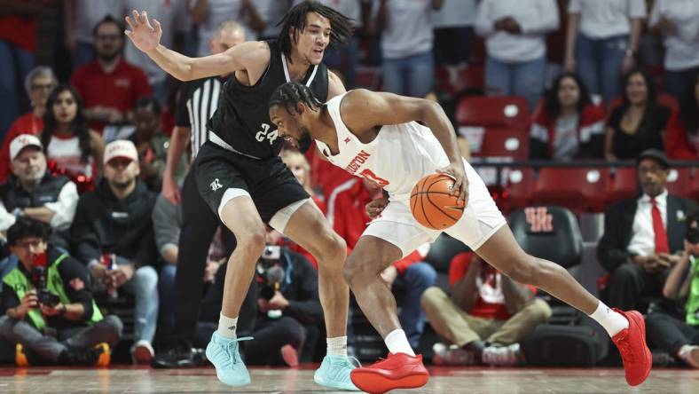 Dec 6, 2023; Houston, Texas, USA; Houston Cougars forward J'Wan Roberts (13) drives with the ball as Rice Owls forward Keanu Dawes (24) defends during the first half at Fertitta Center. Mandatory Credit: Troy Taormina-USA TODAY Sports