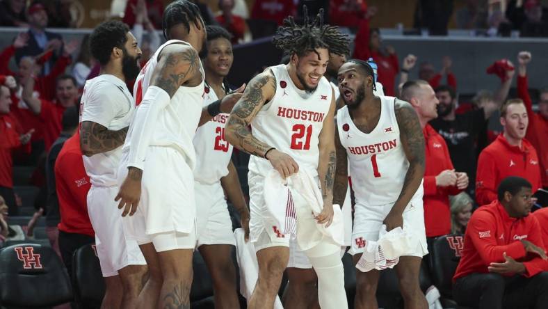 Dec 6, 2023; Houston, Texas, USA; Houston Cougars guard Emanuel Sharp (21) celebrates with teammates after a play during the second half against the Rice Owls at Fertitta Center. Mandatory Credit: Troy Taormina-USA TODAY Sports