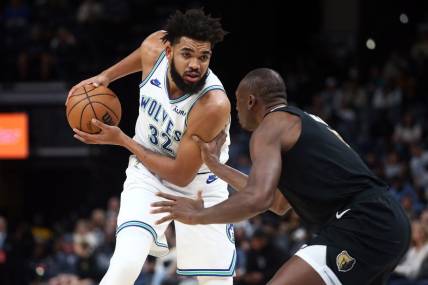Dec 8, 2023; Memphis, Tennessee, USA; Minnesota Timberwolves center-forward Karl-Anthony Towns (32) handles the ball as Memphis Grizzlies center Bismack Biyombo (18) defends during the first half at FedExForum. Mandatory Credit: Petre Thomas-USA TODAY Sports