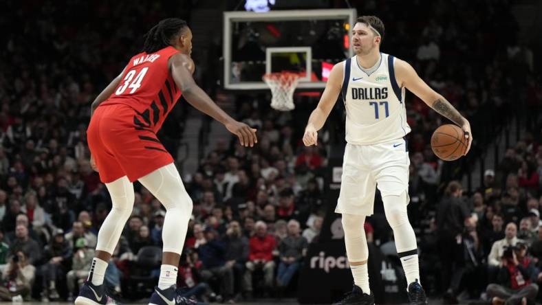 Dec 8, 2023; Portland, Oregon, USA; Dallas Mavericks point guard Luka Doncic (77) brings the ball up court against Portland Trail Blazers forward Jabari Walker (34) during the second half at Moda Center. Mandatory Credit: Soobum Im-USA TODAY Sports