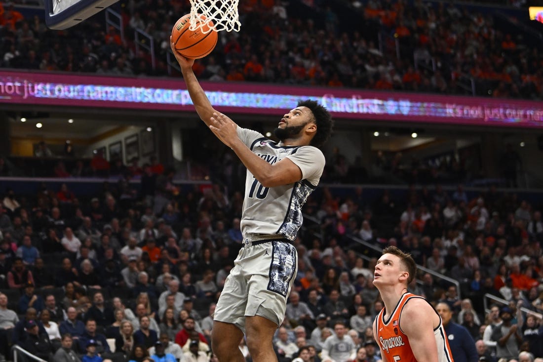 Dec 9, 2023; Washington, District of Columbia, USA; Georgetown Hoyas guard Jayden Epps (10) shoots as Syracuse Orange center Naheem McLeod (10) looks on during the second half at Capital One Arena. Mandatory Credit: Brad Mills-USA TODAY Sports