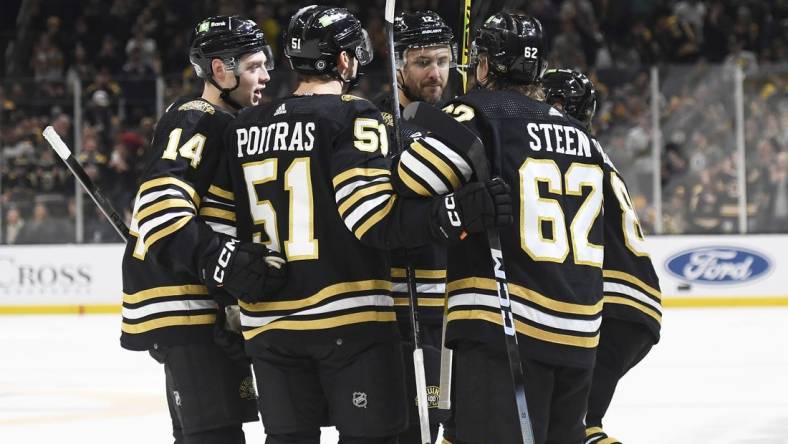 Dec 9, 2023; Boston, Massachusetts, USA;  Boston Bruins defenseman Ian Mitchell (14) center Matthew Poitras (51) center Oskar Steen (62) and defenseman Kevin Shattenkirk (12) celebrate after a goal by right wing David Pastrnak (88) against the Arizona Coyotes during the first period at TD Garden. Mandatory Credit: Bob DeChiara-USA TODAY Sports