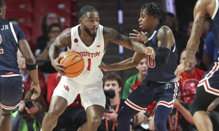 Dec 9, 2023; Houston, Texas, USA; Houston Cougars guard Jamal Shead (1) controls the ball as Jackson State Tigers guard Chase Adams (10) defends during the first half at Fertitta Center. Mandatory Credit: Troy Taormina-USA TODAY Sports