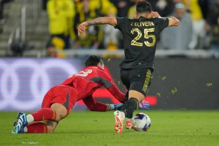 Dec 9, 2023; Columbus, OH, USA; Columbus Crew goalkeeper Patrick Schulte (28) makes a save against Los Angeles FC forward Cristian Olivera (25) during the second half in the 2023 MLS Cup championship game at Lower.com Field. Mandatory Credit: Aaron Doster-USA TODAY Sports