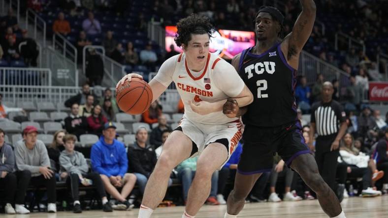 Dec 9, 2023; Toronto, Ontario, CAN; Clemson Tigers forward Ian Schieffelin (4) drives to the net against TCU Horned Frogs forward Emanuel Miller (2) during the second half at Coca-Cola Coliseum. Mandatory Credit: John E. Sokolowski-USA TODAY Sports