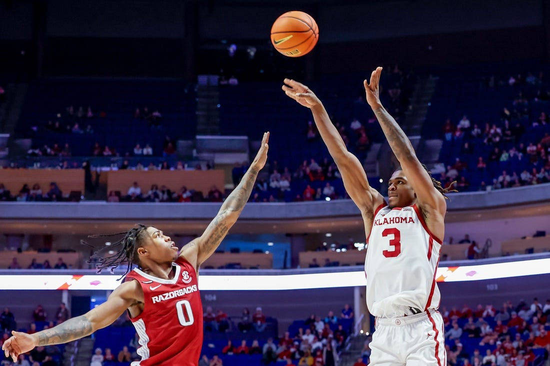 Oklahoma guard Otega Oweh (3) shoots three over Arkansas guard Khalif Battle (0) in the second half during an NCAA basketball game between the Oklahoma Sooners and the Arkansas Razorbacks at the BOK Center in Tulsa, Okla., on Saturday, Dec. 9, 2023.