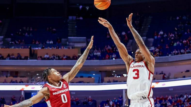 Oklahoma guard Otega Oweh (3) shoots three over Arkansas guard Khalif Battle (0) in the second half during an NCAA basketball game between the Oklahoma Sooners and the Arkansas Razorbacks at the BOK Center in Tulsa, Okla., on Saturday, Dec. 9, 2023.