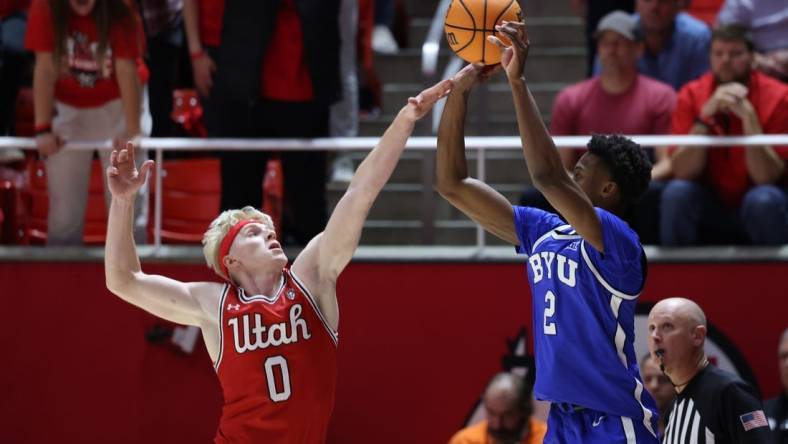 Dec 9, 2023; Salt Lake City, Utah, USA; Brigham Young Cougars guard Jaxson Robinson (2) is fouled by Utah Utes guard Hunter Erickson (0) shooting a three point shot during the second half at Jon M. Huntsman Center. Mandatory Credit: Rob Gray-USA TODAY Sports