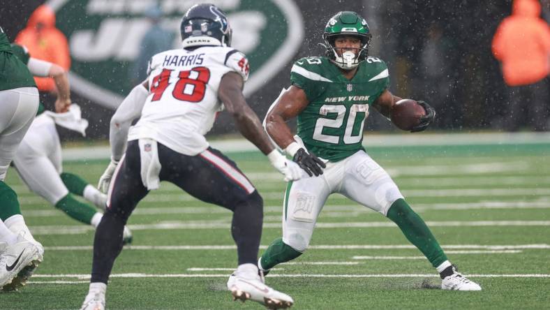 Dec 10, 2023; East Rutherford, New Jersey, USA; New York Jets running back Breece Hall (20) carries the ball asHouston Texans linebacker Christian Harris (48) pursues during the first half at MetLife Stadium. Mandatory Credit: Vincent Carchietta-USA TODAY Sports