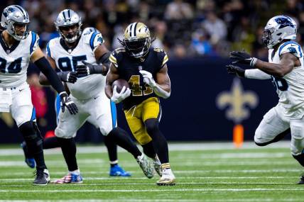 Dec 10, 2023; New Orleans, Louisiana, USA; New Orleans Saints running back Alvin Kamara (41) runs against Carolina Panthers defensive end Henry Anderson (94) during the first half at the Caesars Superdome. Mandatory Credit: Stephen Lew-USA TODAY Sports