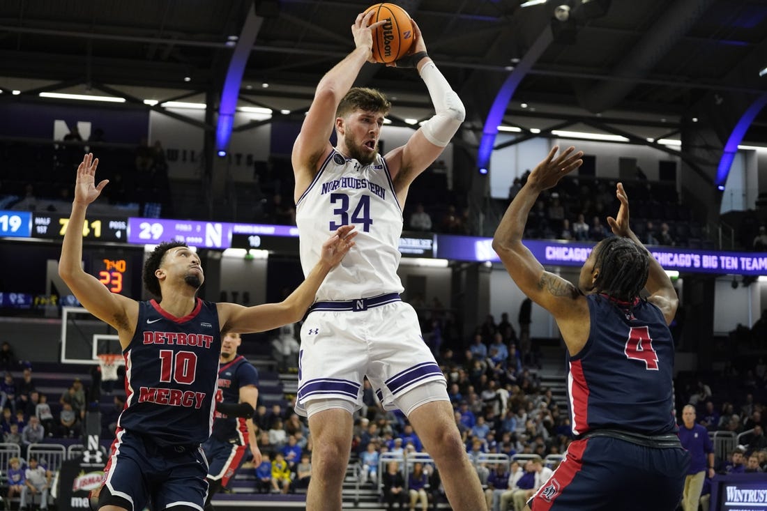 Dec 10, 2023; Evanston, Illinois, USA;Northwestern Wildcats center Matthew Nicholson (34) grabs a reboundd in front of Detroit Mercy Titans guard Marcus Tankersley (4) and  guard Jamail Pink (10) during the first half at Welsh-Ryan Arena. Mandatory Credit: David Banks-USA TODAY Sports