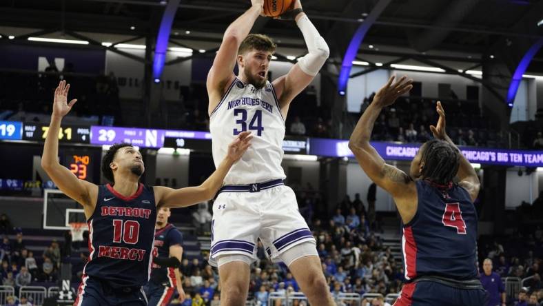 Dec 10, 2023; Evanston, Illinois, USA;Northwestern Wildcats center Matthew Nicholson (34) grabs a reboundd in front of Detroit Mercy Titans guard Marcus Tankersley (4) and  guard Jamail Pink (10) during the first half at Welsh-Ryan Arena. Mandatory Credit: David Banks-USA TODAY Sports