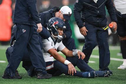 Dec 10, 2023; East Rutherford, New Jersey, USA; Houston Texans quarterback C.J. Stroud (7) with medical staff after suffering an apparent injury during the second half against the New York Jets at MetLife Stadium. Mandatory Credit: Vincent Carchietta-USA TODAY Sports