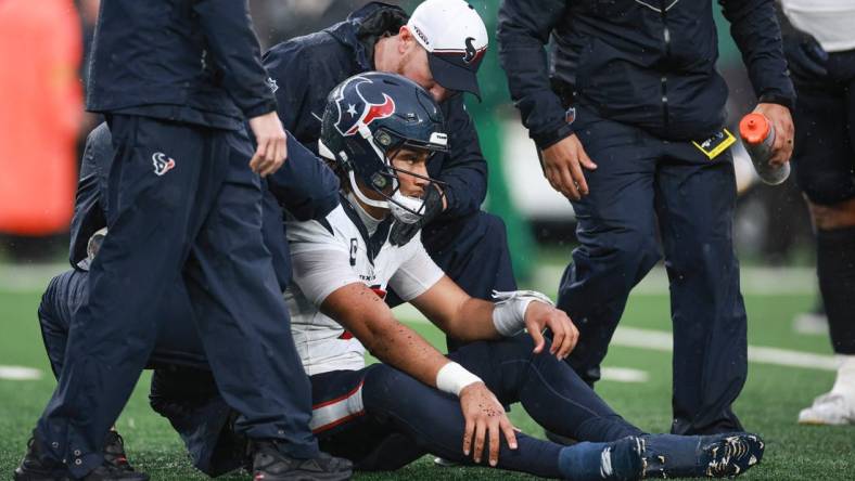 Dec 10, 2023; East Rutherford, New Jersey, USA; Houston Texans quarterback C.J. Stroud (7) with medical staff after suffering an apparent injury during the second half against the New York Jets at MetLife Stadium. Mandatory Credit: Vincent Carchietta-USA TODAY Sports