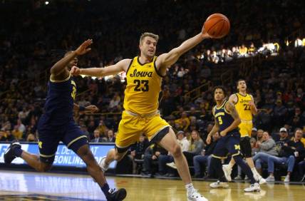 Iowa   s Ben Krikke (23) reaches for a ball, attempting to keep it inbounds Sunday, Dec. 10, 2023 at Carver-Hawkeye Arena in Iowa City, Iowa.