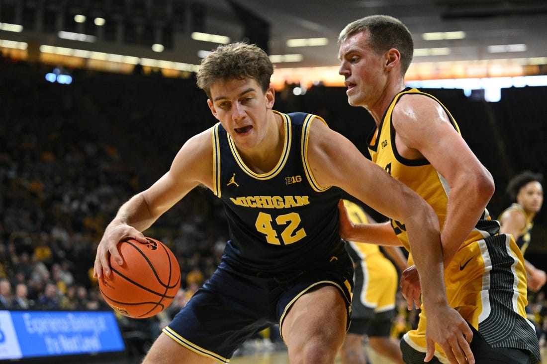 Dec 10, 2023; Iowa City, Iowa, USA; Michigan Wolverines forward Will Tschetter (42) controls the ball as Iowa Hawkeyes forward Payton Sandfort (20) defends during the first half at Carver-Hawkeye Arena. Mandatory Credit: Jeffrey Becker-USA TODAY Sports