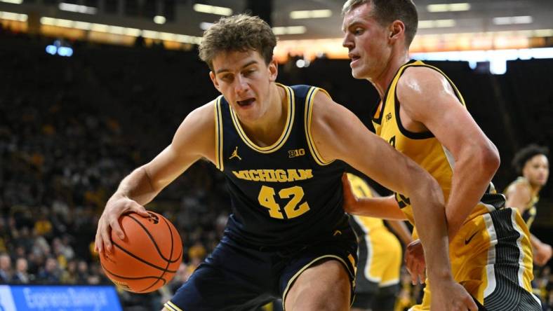 Dec 10, 2023; Iowa City, Iowa, USA; Michigan Wolverines forward Will Tschetter (42) controls the ball as Iowa Hawkeyes forward Payton Sandfort (20) defends during the first half at Carver-Hawkeye Arena. Mandatory Credit: Jeffrey Becker-USA TODAY Sports