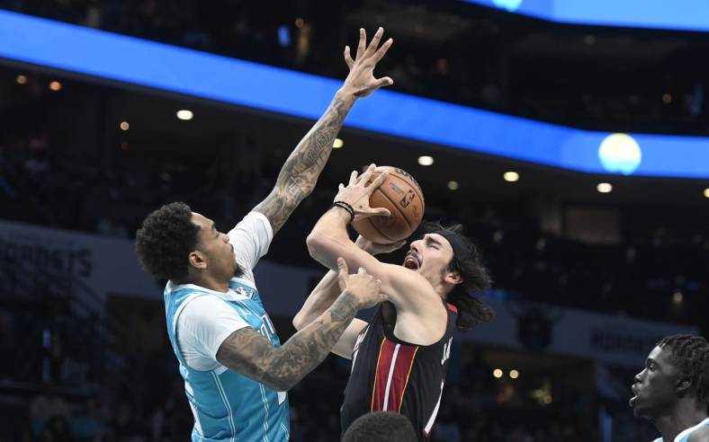 Dec 11, 2023; Charlotte, North Carolina, USA; Miami Heat forward Jaime Jaquez Jr. (11) shoots as he is defended by Charlotte Hornets forward P.J. Washington (25) during the first half at the Spectrum Center. Mandatory Credit: Sam Sharpe-USA TODAY Sports