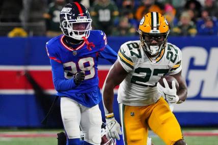 Dec 11, 2023; East Rutherford, New Jersey, USA; Green Bay Packers running back Patrick Taylor (27) runs the ball against New York Giants cornerback Cor'Dale Flott (28) during the second quarter at MetLife Stadium. Mandatory Credit: Robert Deutsch-USA TODAY Sports