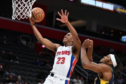 Dec 11, 2023; Detroit, Michigan, USA;  Detroit Pistons guard Jaden Ivey (23) drives to the basket for a layup over Indiana Pacers forward Isaiah Jackson (22) in the fourth quarter at Little Caesars Arena. Mandatory Credit: Lon Horwedel-USA TODAY Sports