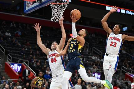 Dec 11, 2023; Detroit, Michigan, USA;  Indiana Pacers guard Tyrese Haliburton (0) drives to the basket against Detroit Pistons forward Bojan Bogdanovic (44) and Pistons guard Jaden Ivey (23) in the second quarter at Little Caesars Arena. Mandatory Credit: Lon Horwedel-USA TODAY Sports