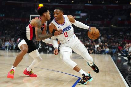 Dec 11, 2023; Los Angeles, California, USA; LA Clippers guard Russell Westbrook (0) dribbles the ball against Portland Trail Blazers guard Anfernee Simons (1) in the first half at Crypto.com Arena. Mandatory Credit: Kirby Lee-USA TODAY Sports