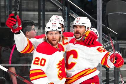 Dec 12, 2023; Las Vegas, Nevada, USA; Calgary Flames defenseman MacKenzie Weegar (52) celebrates with Calgary Flames center Mikael Backlund (11) and Calgary Flames center Blake Coleman (20) after scoring a goal against the Vegas Golden Knights during the first period at T-Mobile Arena. Mandatory Credit: Stephen R. Sylvanie-USA TODAY Sports