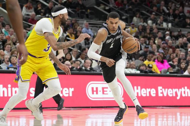 Dec 13, 2023; San Antonio, Texas, USA;  San Antonio Spurs center Victor Wembanyama (1) dribbles against Los Angeles Lakers forward Anthony Davis (3) in the first half at the Frost Bank Center. Mandatory Credit: Daniel Dunn-USA TODAY Sports