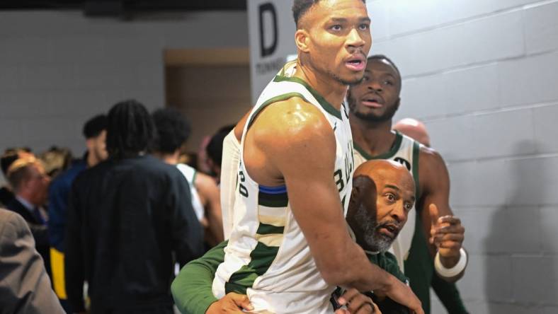 Dec 13, 2023; Milwaukee, Wisconsin, USA;  Milwaukee Bucks forward Giannis Antetokounmpo (34) is restrained by a coach outside the Indiana Pacers locker room after the game at Fiserv Forum. Mandatory Credit: Benny Sieu-USA TODAY Sports