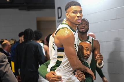 Dec 13, 2023; Milwaukee, Wisconsin, USA;  Milwaukee Bucks forward Giannis Antetokounmpo (34) is restrained by a coach outside the Indiana Pacers locker room after the game at Fiserv Forum. Mandatory Credit: Benny Sieu-USA TODAY Sports