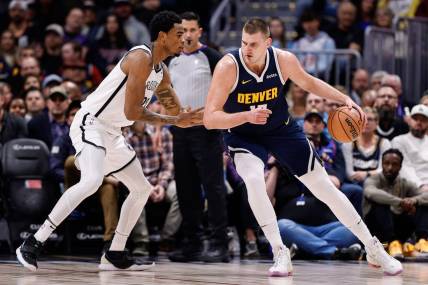 Dec 14, 2023; Denver, Colorado, USA; Denver Nuggets center Nikola Jokic (15) controls the ball as Brooklyn Nets center Nic Claxton (33) guards in the first quarter at Ball Arena. Mandatory Credit: Isaiah J. Downing-USA TODAY Sports