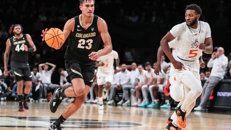 Dec 10, 2023; Brooklyn, New York, USA;  Colorado Buffaloes forward Tristan da Silva (23) and Miami (Fl) Hurricanes guard Wooga Poplar (5) at Barclays Center. Mandatory Credit: Wendell Cruz-USA TODAY Sports