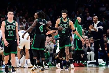 Dec 15, 2023; Boston, Massachusetts, USA; Boston Celtics forward Jayson Tatum (0) reacts to his shot with guard Jrue Holiday (4) during the first half against the Orlando Magic at TD Garden. Mandatory Credit: Eric Canha-USA TODAY Sports