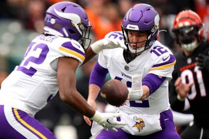 Dec 16, 2023; Cincinnati, Ohio, USA; Minnesota Vikings quarterback Nick Mullens (12) hands the ball off to Minnesota Vikings running back Ty Chandler (32) in the first quarter of the game against the Cincinnati Bengals at Paycor Stadium. Mandatory Credit: Kareem Elgazzar/The Enquirer-USA TODAY Sports